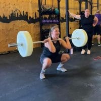 Woman doing barbell squats on training at at CrossFit Landskrona